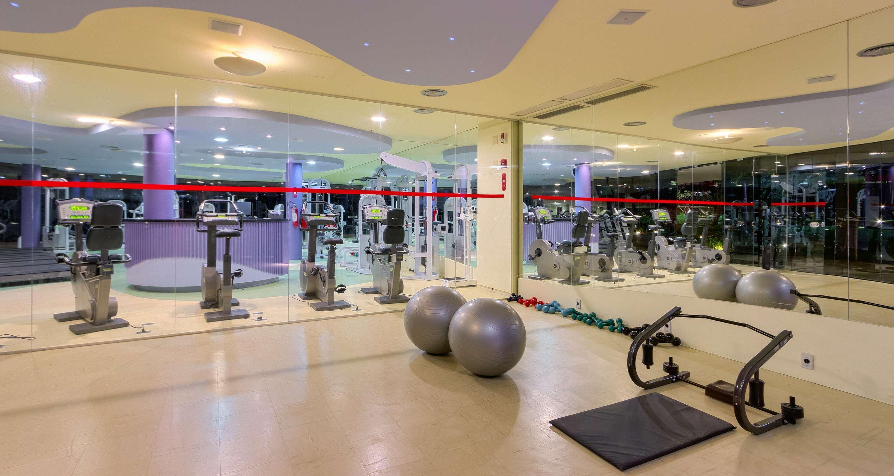 Royal Tulip Brasilia Alvorada Hotell Exteriör bild The photo depicts a gym or fitness area. In the foreground, there are two large exercise balls and a mat on the floor. Behind them, there is a wall of mirrors that reflects various gym equipment, including exercise machines and bikes. The lighting in